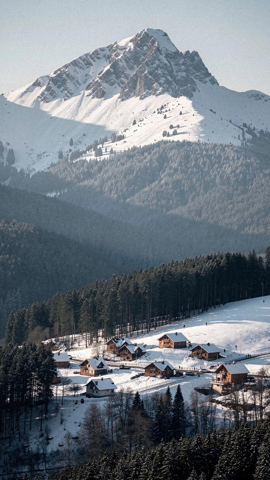 Snow-covered Carpathian ridge above a mountain resort village in winter